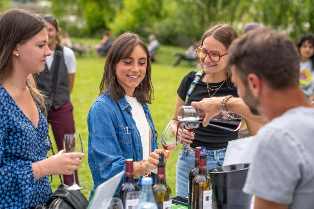 Trois personnes se faisant servir un verre de vin