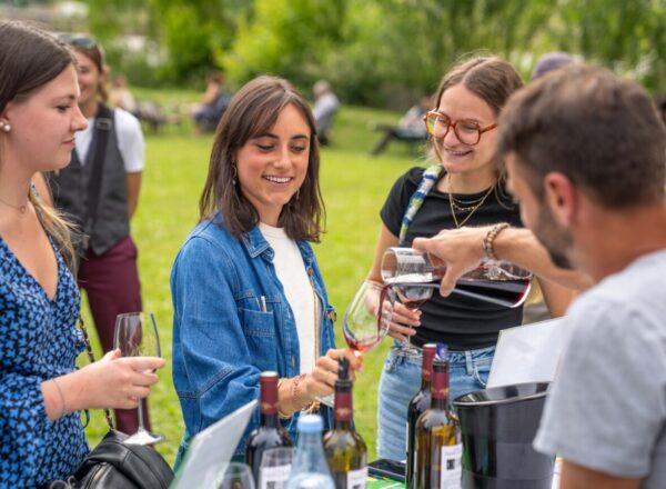 Trois personnes se faisant servir un verre de vin