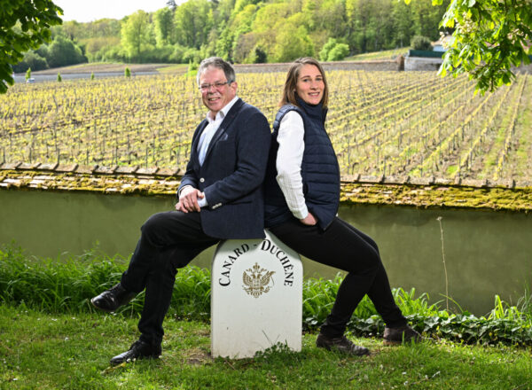 Cynthia Fossier et Laurent Fédou se tiennent devant un paysage de vignes.