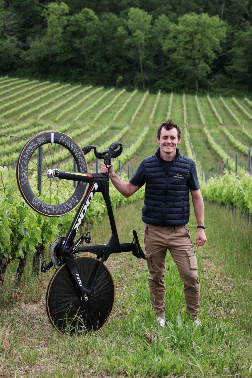 Thomas Boudat avec son vélo dans ses vignes