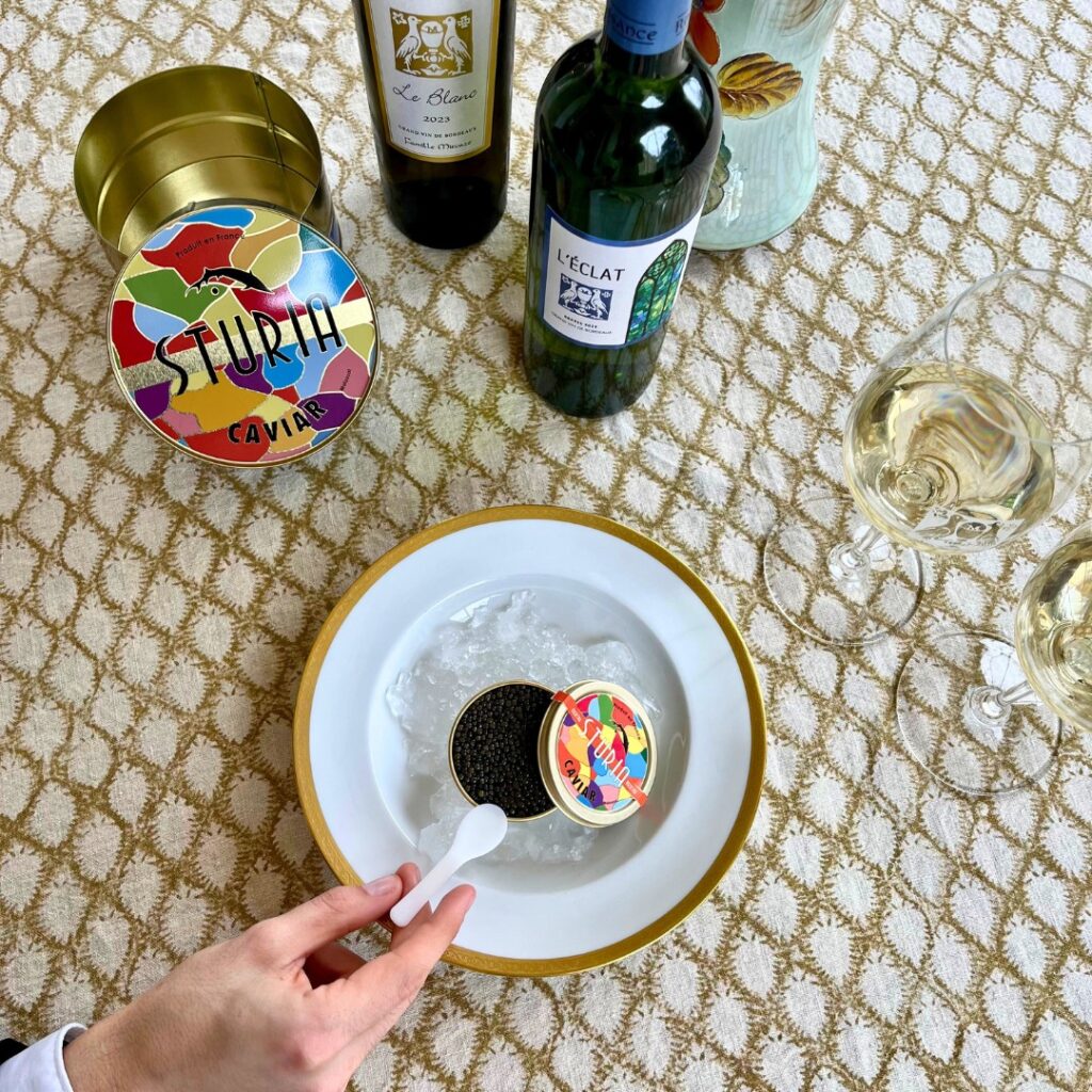 boite de caviar sur une assiette avec une bouteille de vin