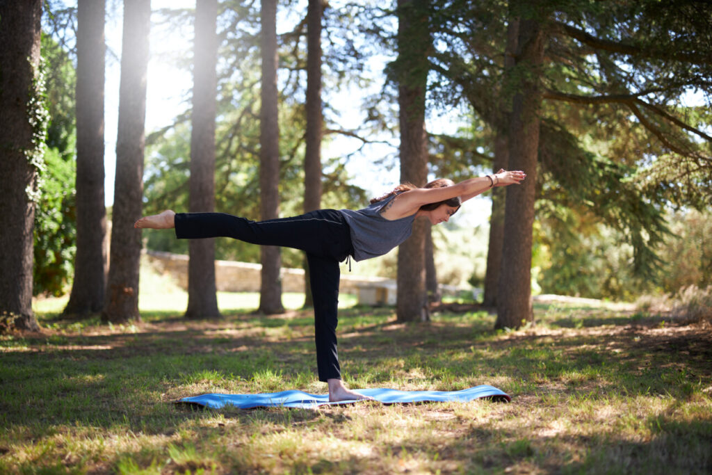 une dame fait du yoga dans la forêt 