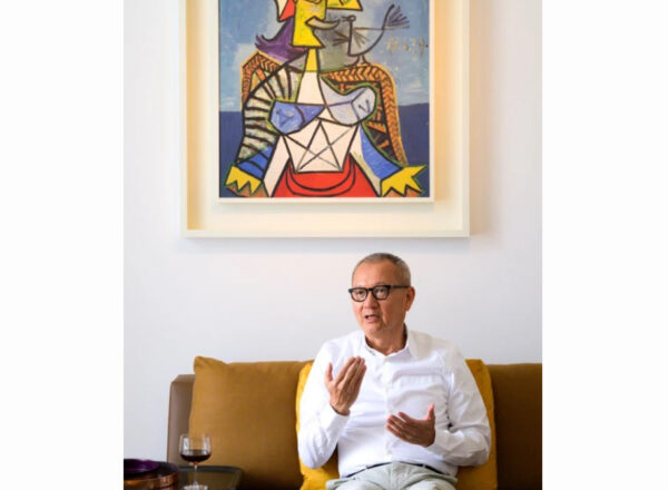 Pierre Chen assis sur un capé devant une oeuvre d'art de Picasso
