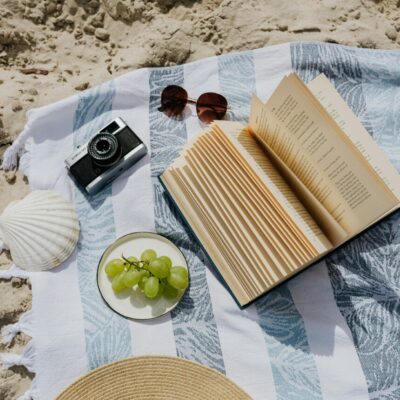 livre sur la plage avec raisin et chapeau