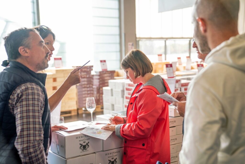 Femme qui achète une caisse vin lors de la Foire aux Seconds Vins