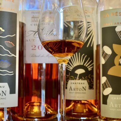 Verre d'armagnac et différentes bouteilles d'armagnac de château Arton