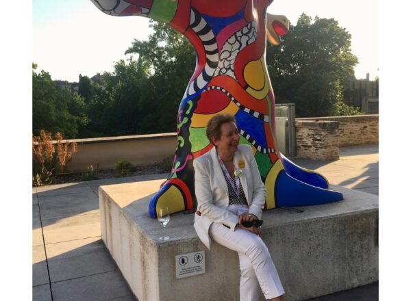 Evelyne de Pontbriand assise devant une statue