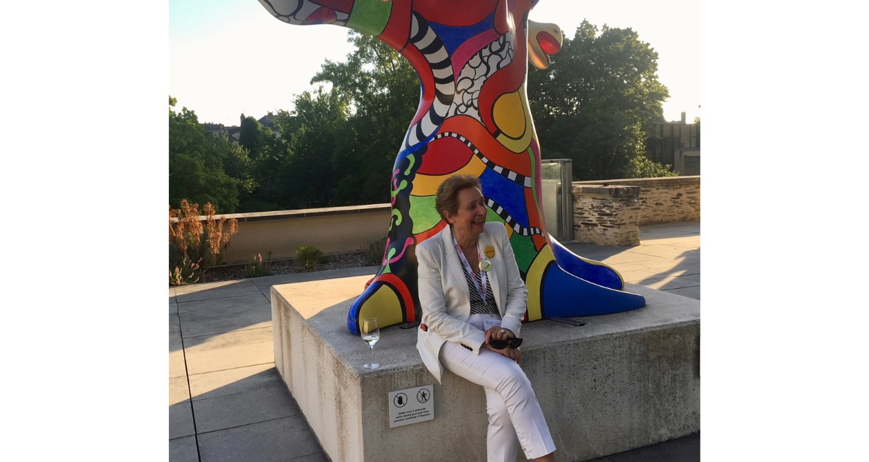 Evelyne de Pontbriand assise devant une statue