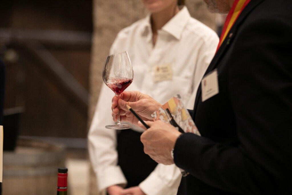 homme tient un verre de vin rouge 